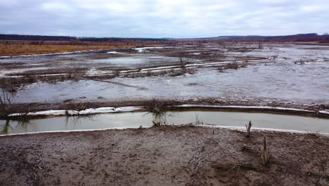 Nature in danger. Drought on earth. Narrow stream of dirty water of dried lake. Climate change. Ecological disaster. Environmental pollution. Motion camera back.