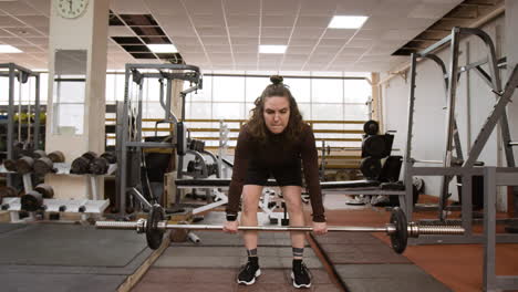 woman performing deadlift exercise in a gym