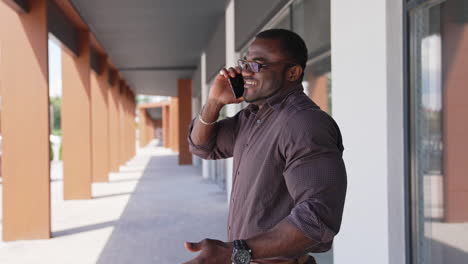 black businessman using mobile phone. businessman calling while walking in the street