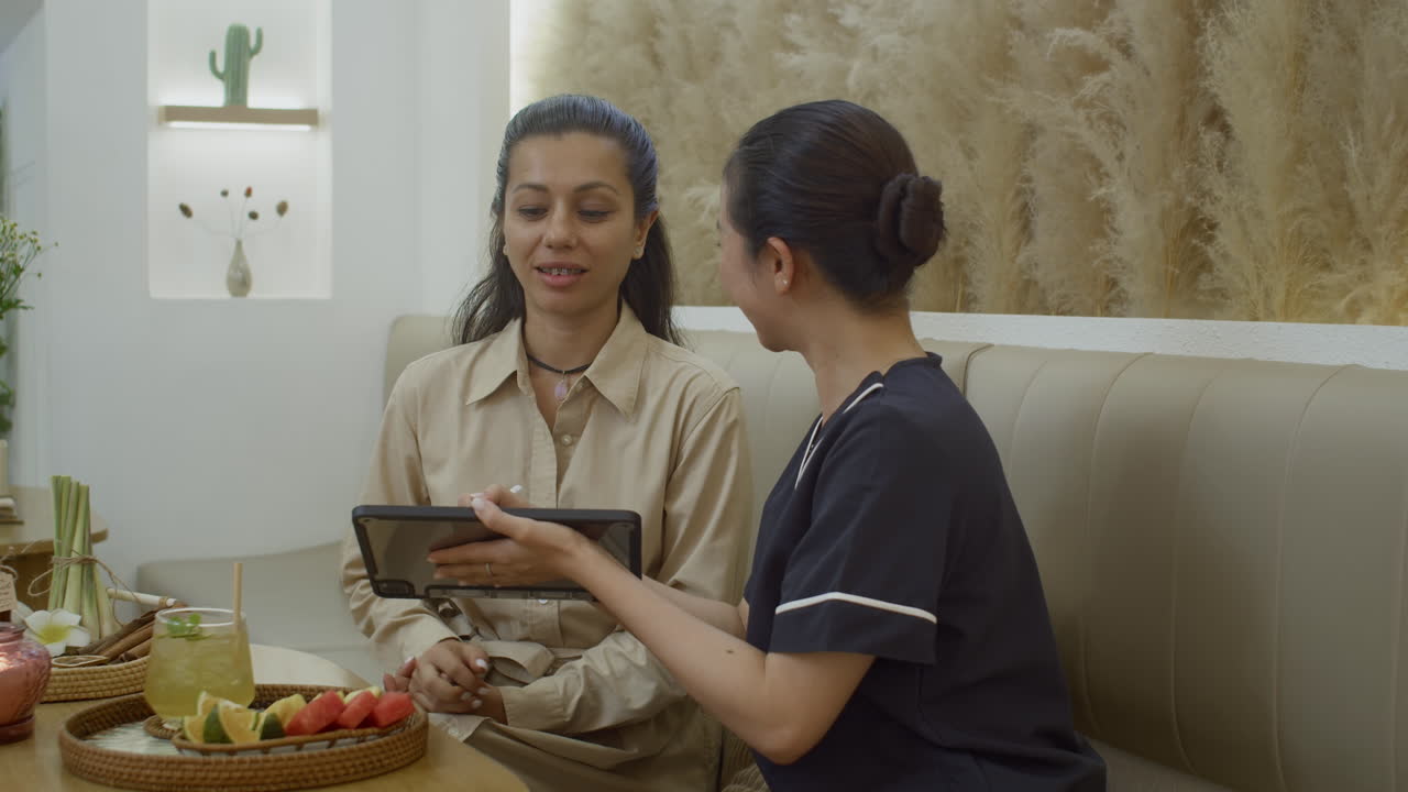 Hospitable Manager Offering Beauty Procedures to Female Client at Salon