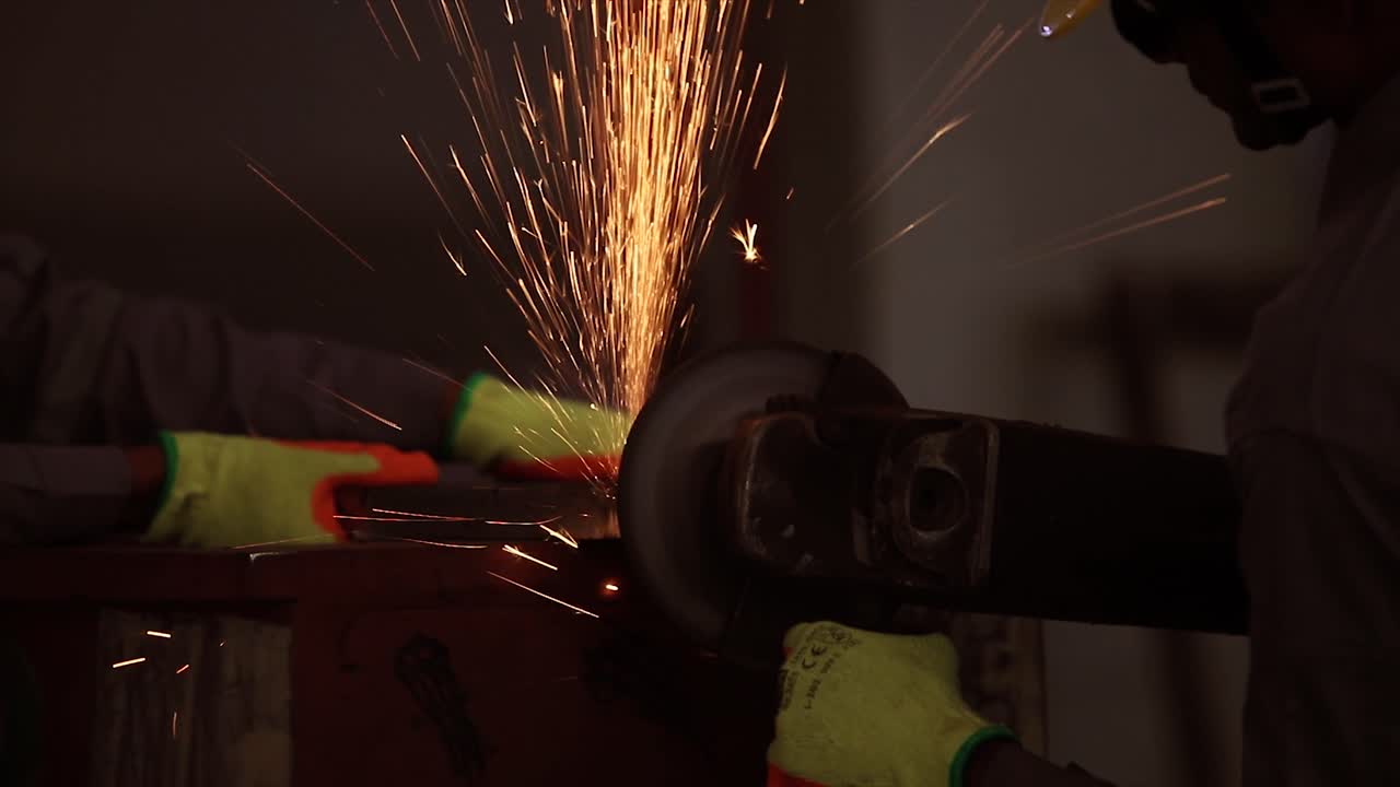 el concepto de seguridad primero, el hombre trabaja con sierra circular, moscas de chispa del metal caliente, el trabajo duro del hombre