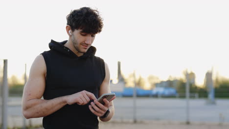 man using phone outdoors during sunset