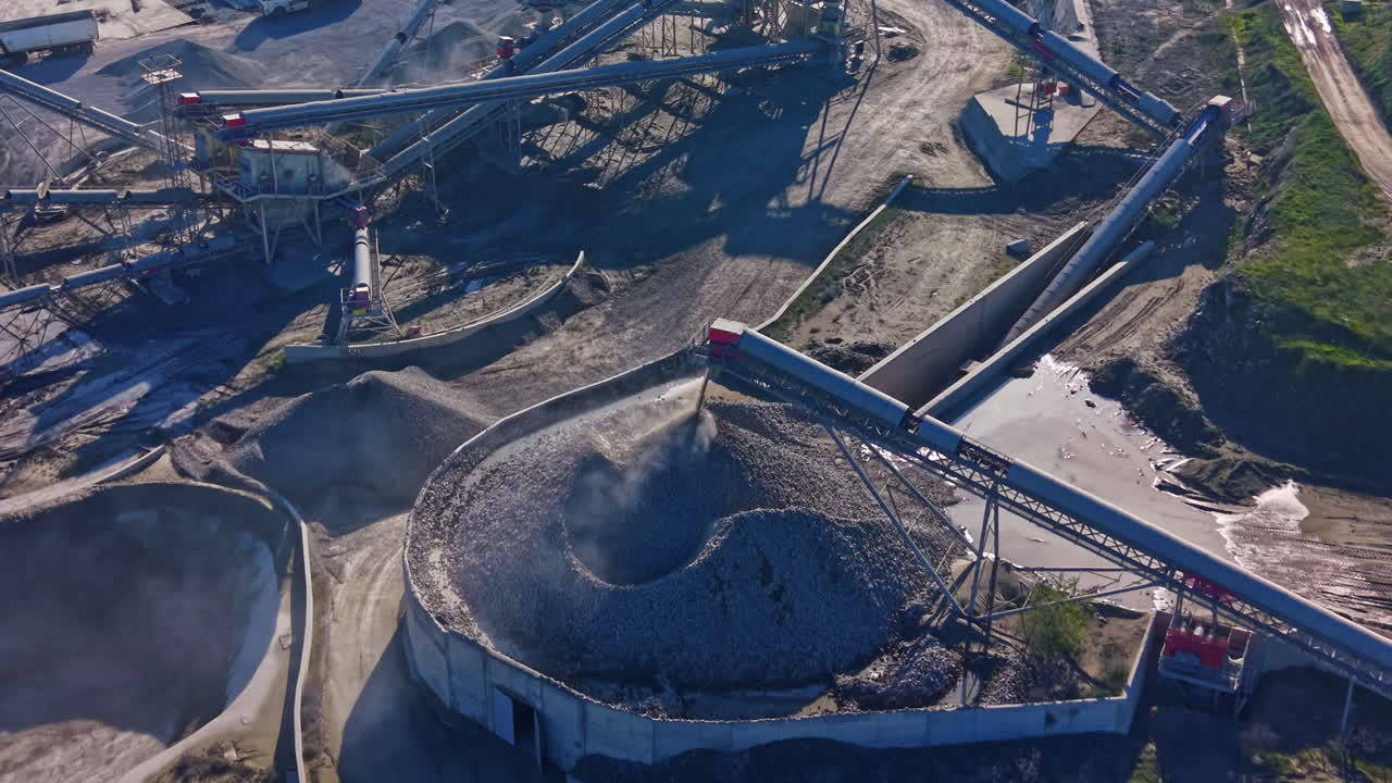 Industrial site bustling with activity in a gravel processing facility during bright daylight under clear skies