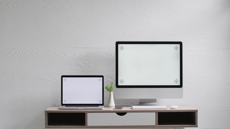 Video di computer e laptop su tavolo in legno con spazio per la copia in ufficio.