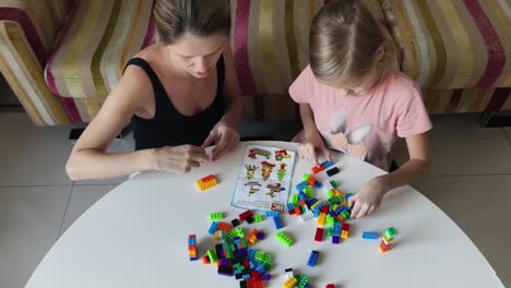 mother and daughter building with blocks