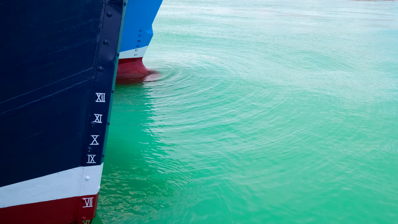 Close-up of Ship Hull and Draft Marks in Calm Turquoise Water
