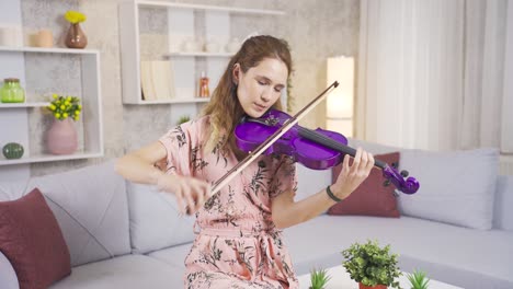 young musician woman playing her violin at home, composing songs, producing.