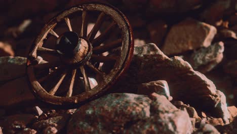 old wooden wheel on rocks