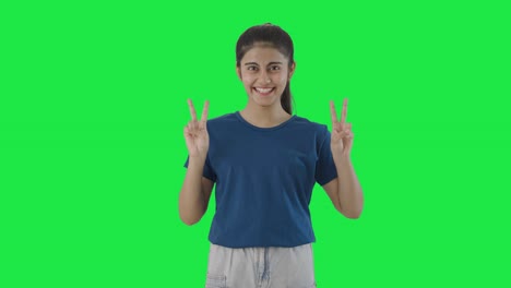 Happy-Indian-teenage-girl-showing-victory-sign-Green-screen