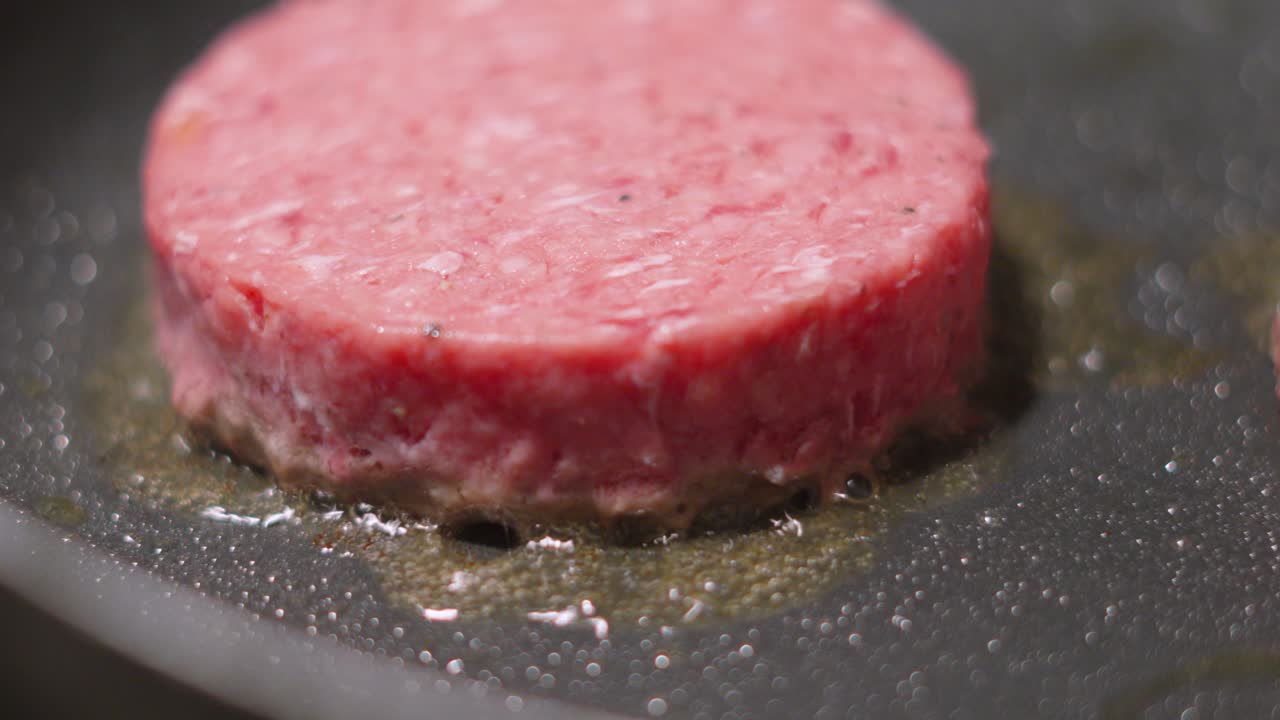 Close Up of Raw Aberdeen Angus Beef Burgers Cooking in Frying Pan. Delicious Meat Pattie Sizzling in Hot Oil. High Fat Food Clip