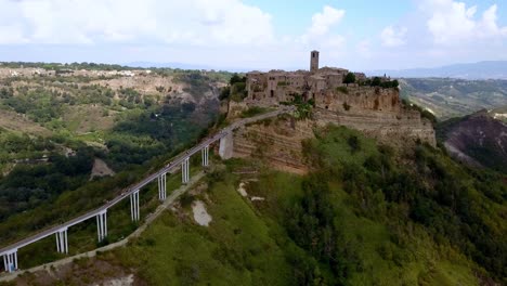 Civita-di-Bagnoregio-in-Tuscany-Italy-with-access-bridge,-Aerial-circling-reveal-shot