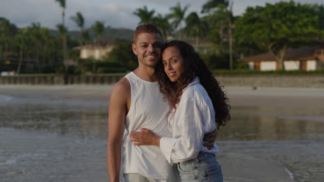 una pareja joven posando en la playa.