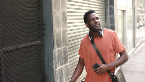 a young african american man stands by a closed shop with copy space in new york city