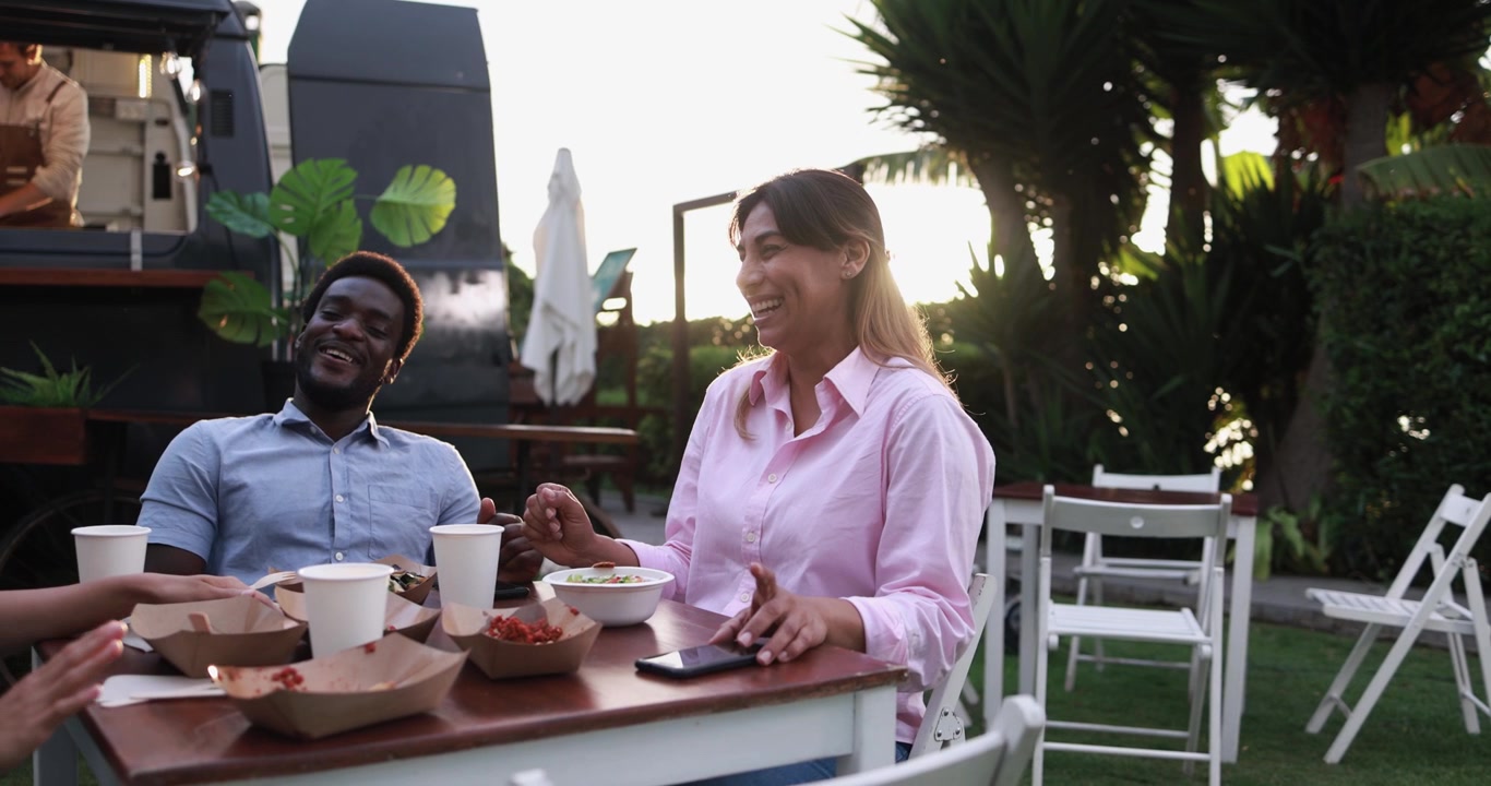 Diverse Friends Laughing and Eating at Outdoor Food Truck Event
