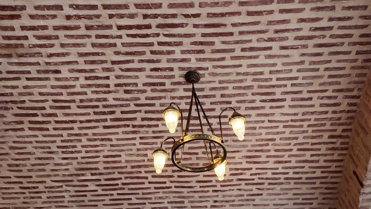 Chandelier hanging from a rustic brick ceiling