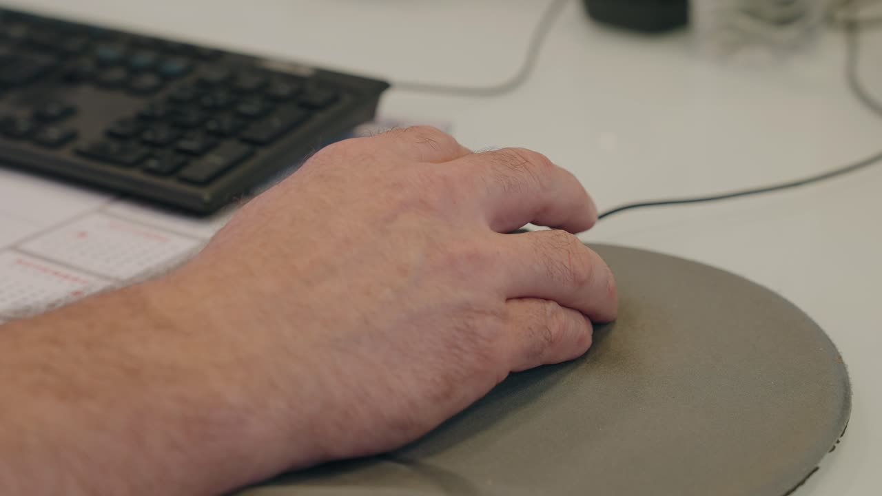 person working at desk with mouse and keyboard visible