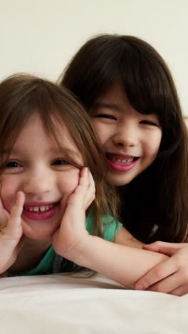 two sisters playing together in a bedroom