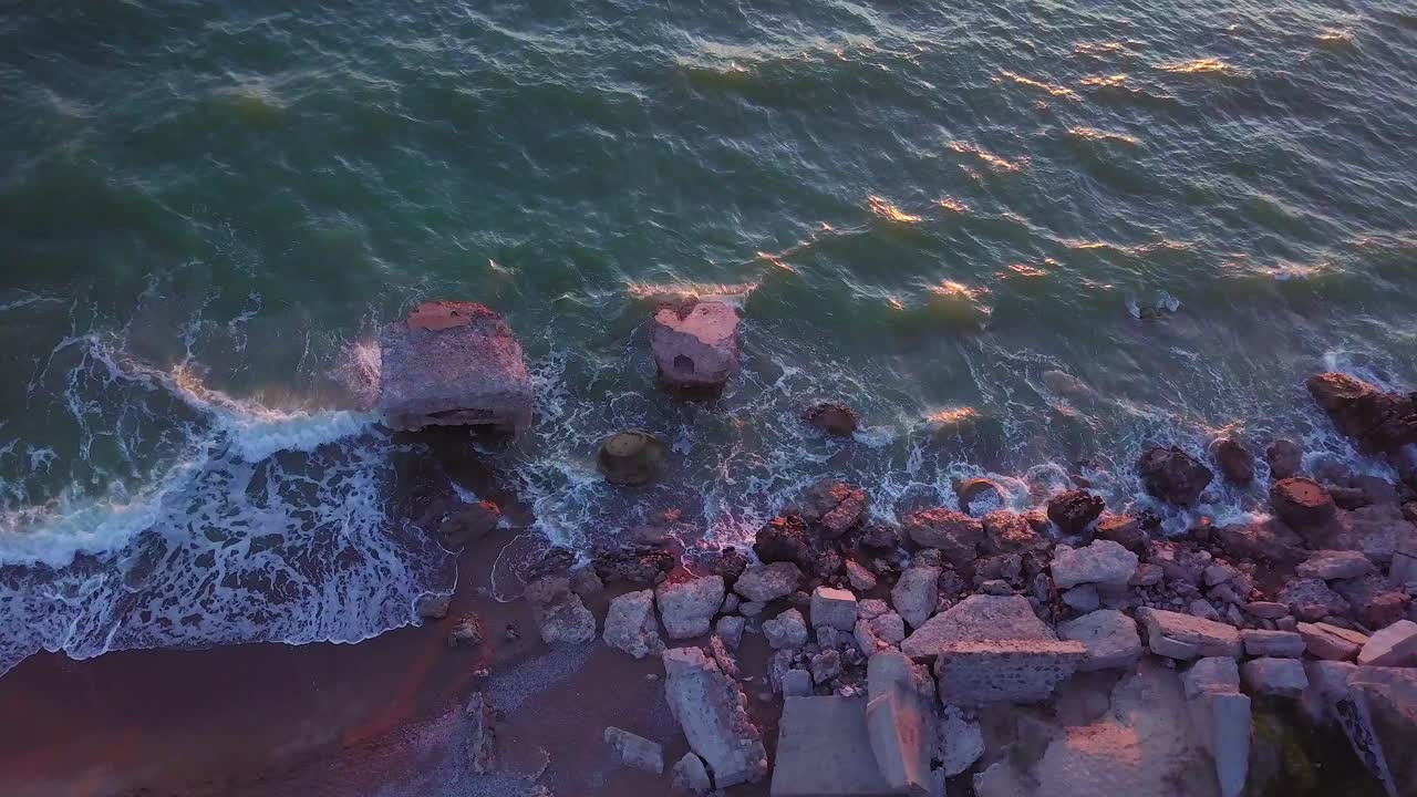 вид с высоты птичьего полета на заброшенные приморские фортификационные сооружения в каросте северные форты на пляже балтийского моря, плеск волн, золотой час заката, дрон dolly shot moving left