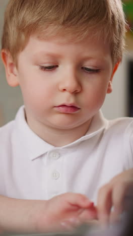 schoolgirl in back correcting corsage plays short theme on piano to brother at home closeup. toddler boy looks at sister hand on instrument keyboard with attention