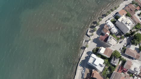 aérea mira directamente hacia abajo en el agua de mar verde en la orilla de la ciudad