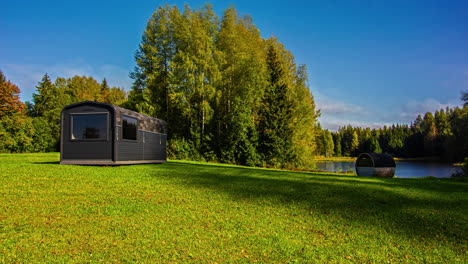 time laps of modern cabin in an open grassland space near a lake and forest