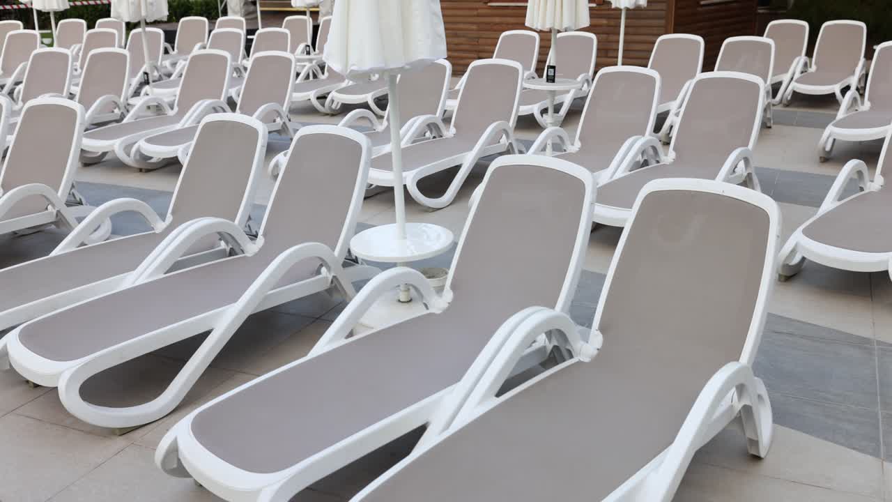 Row of Empty Lounge Chairs by the Pool