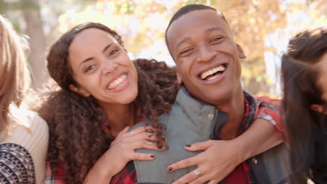 Close-up-handheld-pan-of-three-couples-piggybacking-outdoors