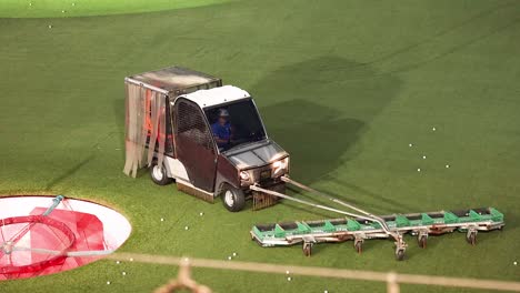 machine collecting golf balls on a driving range