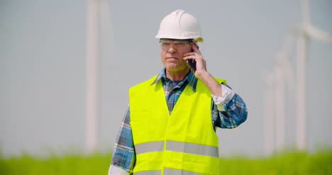 Wütender-Ingenieur,-Der-Am-Handy-Gegen-Windmühlenfarm-Spricht