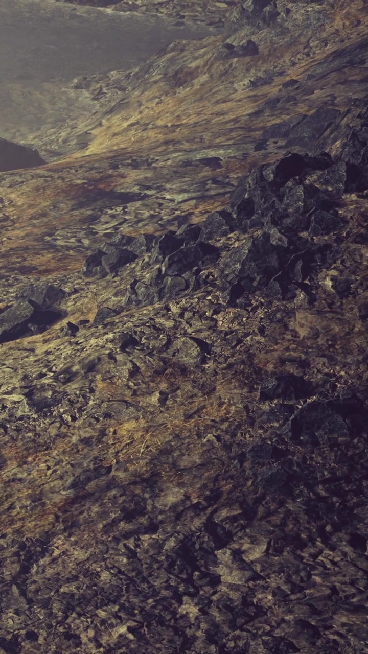 Terreno rochoso com vegetação esparsa durante o dia perto de montanhas