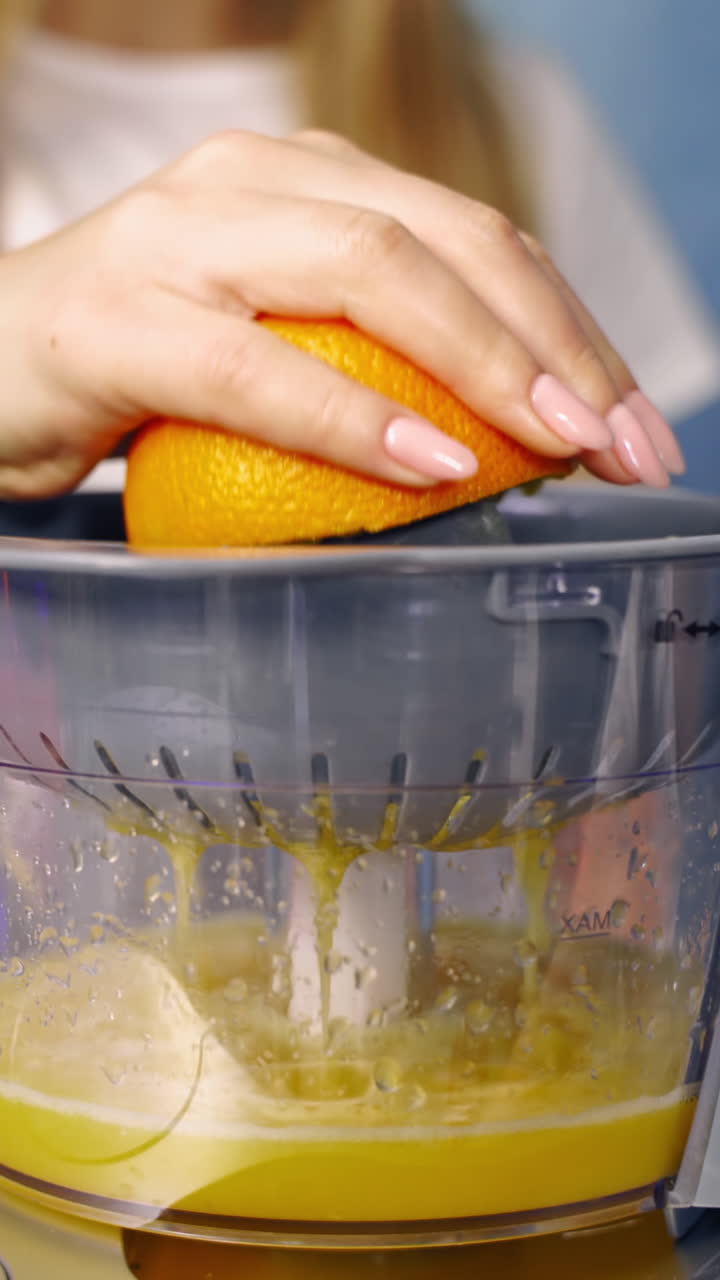 Mujer haciendo zumo de naranja. Primer plano de mujer haciendo zumo con naranjas frescas.