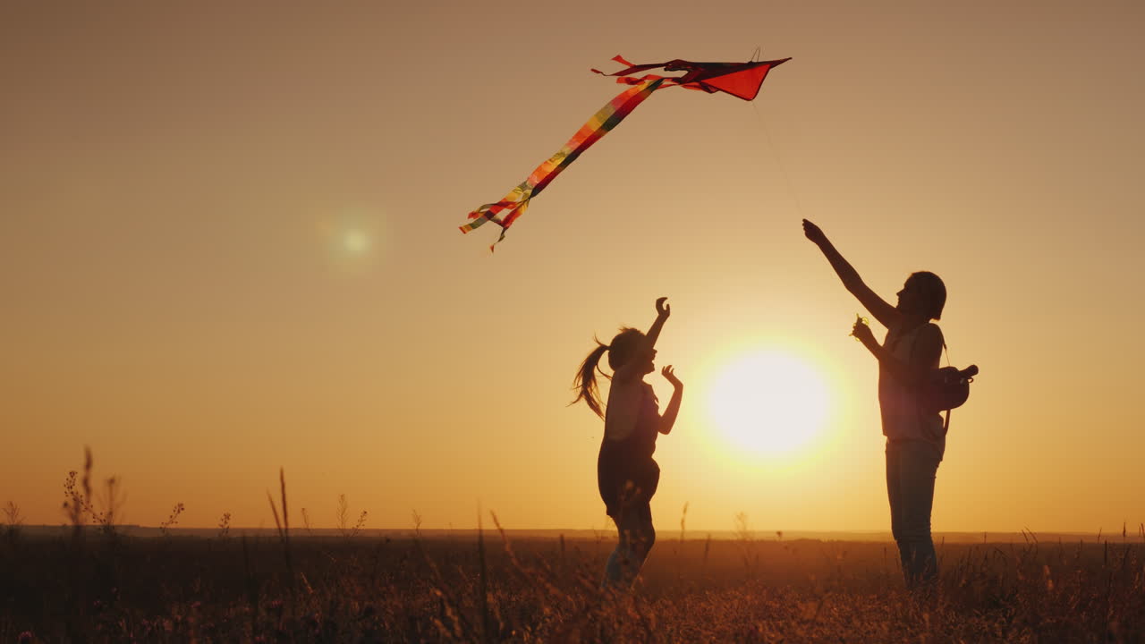 mamá juega con su hija descuidadamente lanza una cometa vida feliz verano actividad concepto 4k video