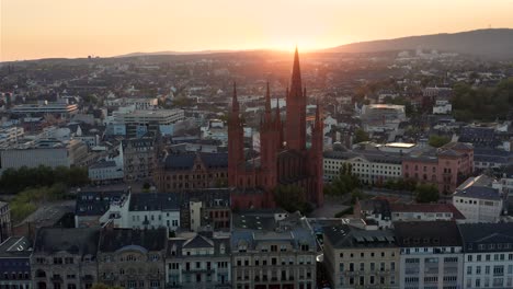 Dando-Vueltas-Alrededor-De-La-Marktkirche-En-Wiesbaden-Alemania-En-Una-Tarde-De-Verano-Con-Poca-Luz-Con-Un-Drohne