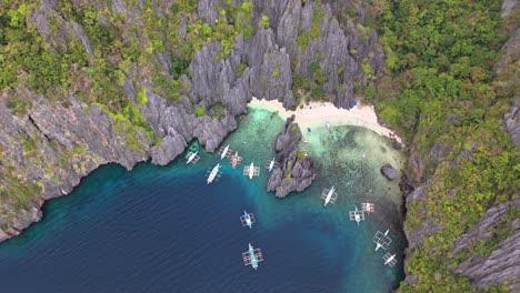 bird's-eye survey of the secret lagoon, jiji's beach, with boats in miniloc island, in philippines