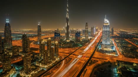 nighttime aerial view of dubai's illuminated cityscape and highways