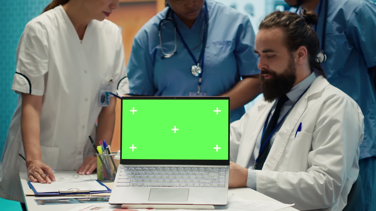 Medical team reviewing patient data on a laptop with green screen