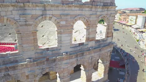 aerial view of arena di verona, italy. the video is made of a drone that rises from behind a wall. a view of the arena and the city opens.