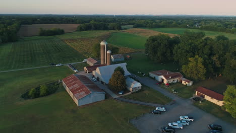 vista aérea de la granja con granero y silos de grano con campos detrás, 4k