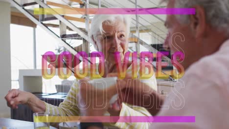 animation of good vibes in pink over happy caucasian senior couple having coffee talking at home