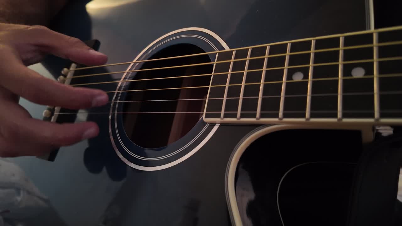 Playing Guitar and Close up of fingers plucking acoustic guitar strings