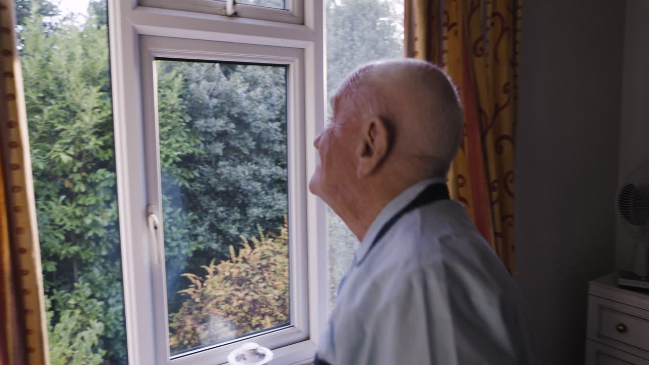 Elderly man looking out the window