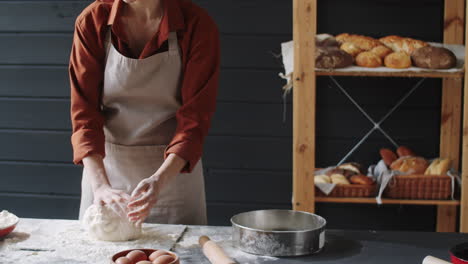 woman making dough in bakery kitchen