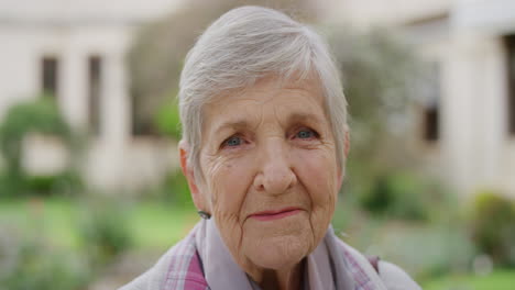 close up portrait of senior caucasian woman smiling happy looking at camera enjoying sunny day in park