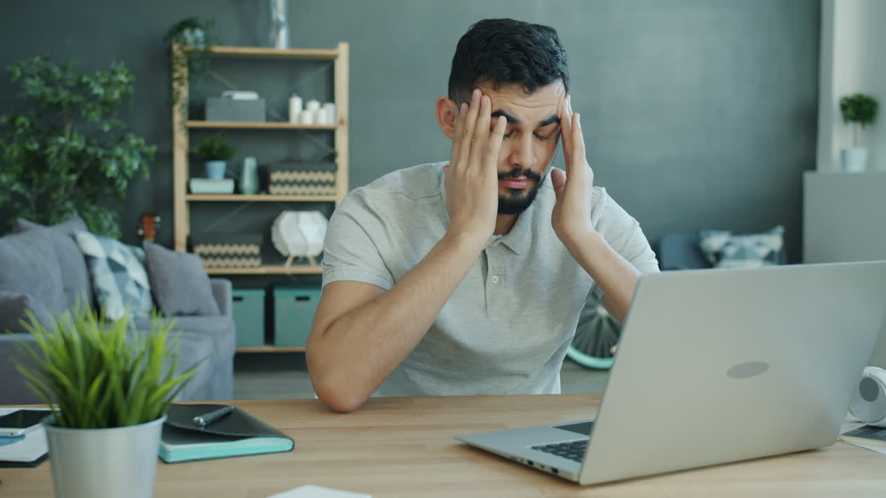 Stressed Man Working at Laptop