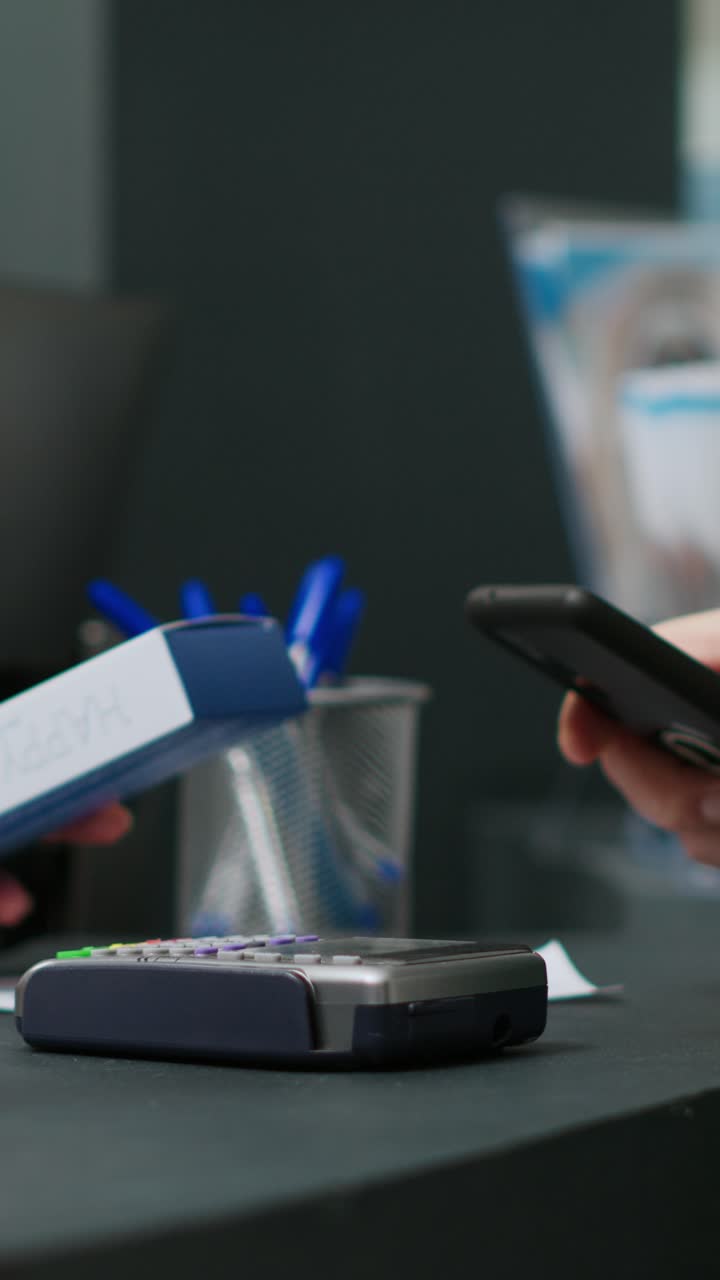 Vertical video: Elderly person paying medicaments and drugs with telephone and nfc