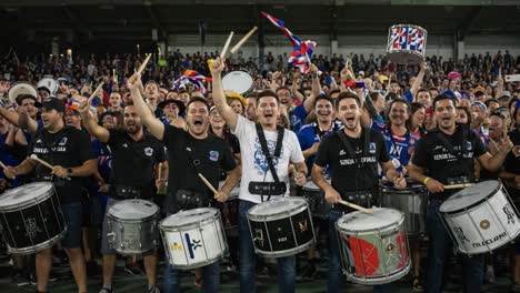 energetic crowd of drummers celebrates with passionate rhythm and joyful shouts at a vibrant live event, capturing the excitement of music and community spirit