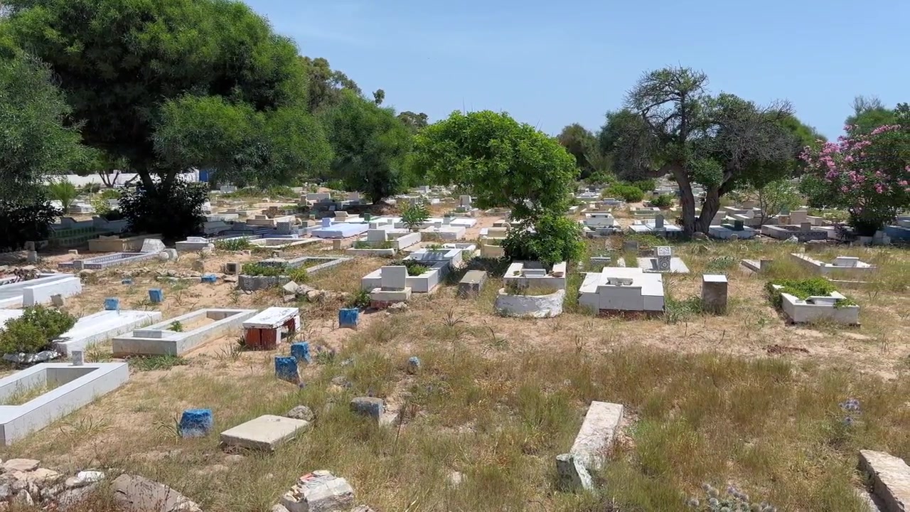 Tombe bianche e semplici in un vecchio cimitero con un'atmosfera tranquilla di mezzogiorno ad Hammamet, Tunisia