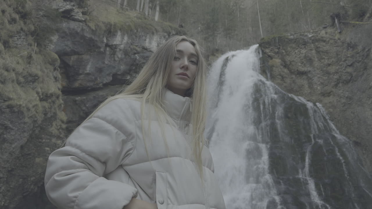 Woman in front of a waterfall in a forest