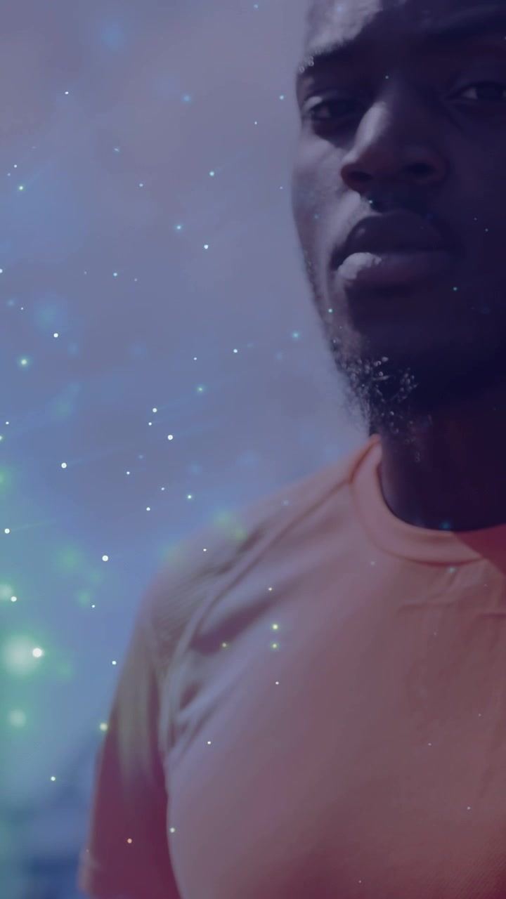 Vertical video: Man holding basketball as camera rising, sparkle overlay revealing face for sports