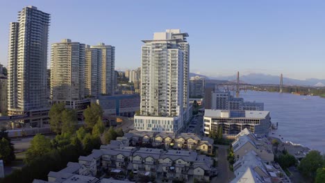 aerial panaramic new westminster quay east north waterfront buildings commercial industrial fraser river skytrain railway horbor of industrial import export across residential quay of luxury homes